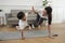 Asian Thai mother and son practice yoga on living room floor together