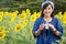 Asian thai woman use camera shooting photo sunflower flower field