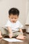 Asian toddler busy drawing