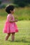 Asian toddler girl in green field looking up