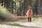 Asian toddler girl walking alone in a forest, back view