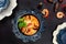 Asian Tom Yam soup in a blue textured plate. Photo on a dark background. Copy of the space. Excellent serving of this dish.The