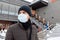 Asian tourist man wearing mask protecting from Coronavirus during winter