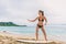 Asian tourist woman on Hawaii beach learning to surf at surfing school in Waikiki, Honolulu, Oahu. Girl having fun