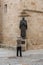 Asian tourists take a photo of the statue of San Pedro de Alcantara located at the gates of the cathedral of Santa Maria