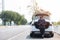 Asian traveler man wearing face mask and sitting on car with hightway road background