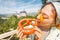 Asian traveller girl eats crispy pretzel in the background of the legendary Neuschwanstein castle. Tourism in Bavaria