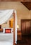 Asian tropical bedroom four poster bed white curtain and wooden closet