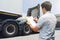 Asian Truck Driver is Checking the Truck`s Safety Maintenance Checklist. Lorry Driver. Inspection Truck Safety Semi Truck Wheels.