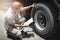 Asian a truck driver holding clipboard his checking safety a truck wheels and tires. semi truck transportation.