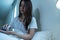 Asian unhappy sick girl in pajamas take medicine before sleep on bed. Attractive beautiful young woman feel frustrated to take