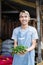 Asian vegetable seller man smiles while holding green chilies