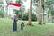 Asian veiled mother wit doughter flapping Indonesian flag