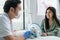 Asian veterinarian examine cat during appointment in veterinary clinic. Professional vet doctor male sit on table with stethoscope