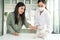 Asian veterinarian examine cat during appointment in veterinary clinic. Professional vet doctor woman sit on table, work and check