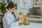 asian veterinarian examining adorable cat with stethoscope at clinic