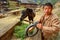 Asian Village, Rural Chinese peasant farmer is holding horse-collar.