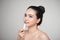 Asian woman applying hygienic lip balm over grey background