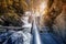 Asian woman with backpack hiking along waterfalls of Pollat river in Schwangau region near Neuschwanstein