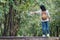 Asian woman backpacker standing on countryside road with tree in