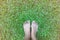 Asian woman bare foot standing on green grass for relaxation