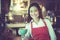 Asian woman barista smiling with a cup of coffee in her hand