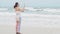 Asian woman on beach, using mobile smart phone taking photo of the view. wave hitting stone on the beach. freedom traveling. techn