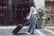 Asian woman beaming carrying a suitcase black to travel on vacation