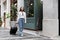 Asian woman beaming carrying a suitcase black to travel on vacation