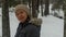 Asian woman with beige knit hat standing in snow