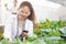 Asian woman biology scientist collecting data in agriculture farm for good plant vegetable productivity