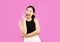 Asian woman in black crop top using smartphone calling and chatting on pink background