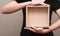 Asian woman in black T-shirt stood bringing a wooden box