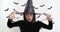 Asian woman in black witch costume casting spell to camera, Halloween magic concept