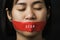 Asian woman blindfold wrapping mouth with red adhesive tape