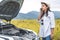 Asian woman calling car mechanic service for repairing breakdown broken car by mobile phone during driving to destination. Car