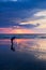 Asian woman catching saltwater fish on the beach at dusk