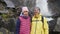 Asian woman, caucasian man stands together near waterfall