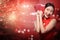 Asian woman in cheongsam dress holding angpao