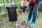 Asian woman clean and collecting bin dry leaves garbage in park, recycle, environment protection. Team with recycle project