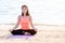 Asian woman close eyes and doing Hand Mudra yoga pose and meditates on sand at coastline beach, Calm and relax