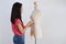 Asian woman cloth designer measuring waist of female mannequin on white back ground.