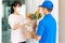 Asian woman costumer wearing face mask and glove receive groceries bag of food, fruit, vegetable and drink from delivery man   in