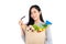 Asian woman with credit card holding paper bag full of groceries isolated on studio white background