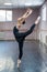 Asian woman dancing in ballet class doing bilman pose.