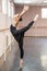 Asian woman dancing in ballet class doing bilman pose.