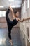 Asian woman dancing in ballet class doing bilman pose.