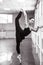 Asian woman dancing in ballet class doing bilman pose. Monochrome.