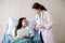 Asian woman dentist talking with female patient explain with tooth model and preparing to treatment at dental center