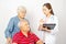 Asian woman Doctor talking to senior couple in wheelchair at hospital. Beautiful asian doctor taking care of patient in wheelchair